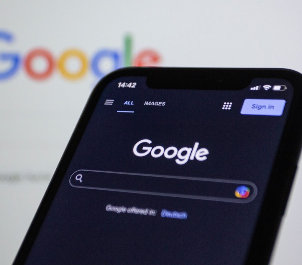 a close up of a cell phone with the google logo in the background