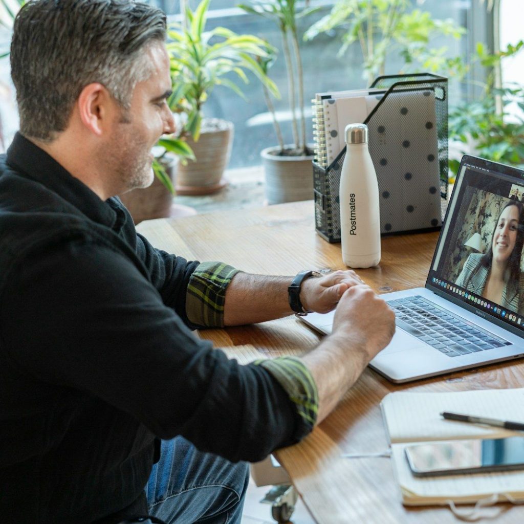 man in black sweater using macbook pro