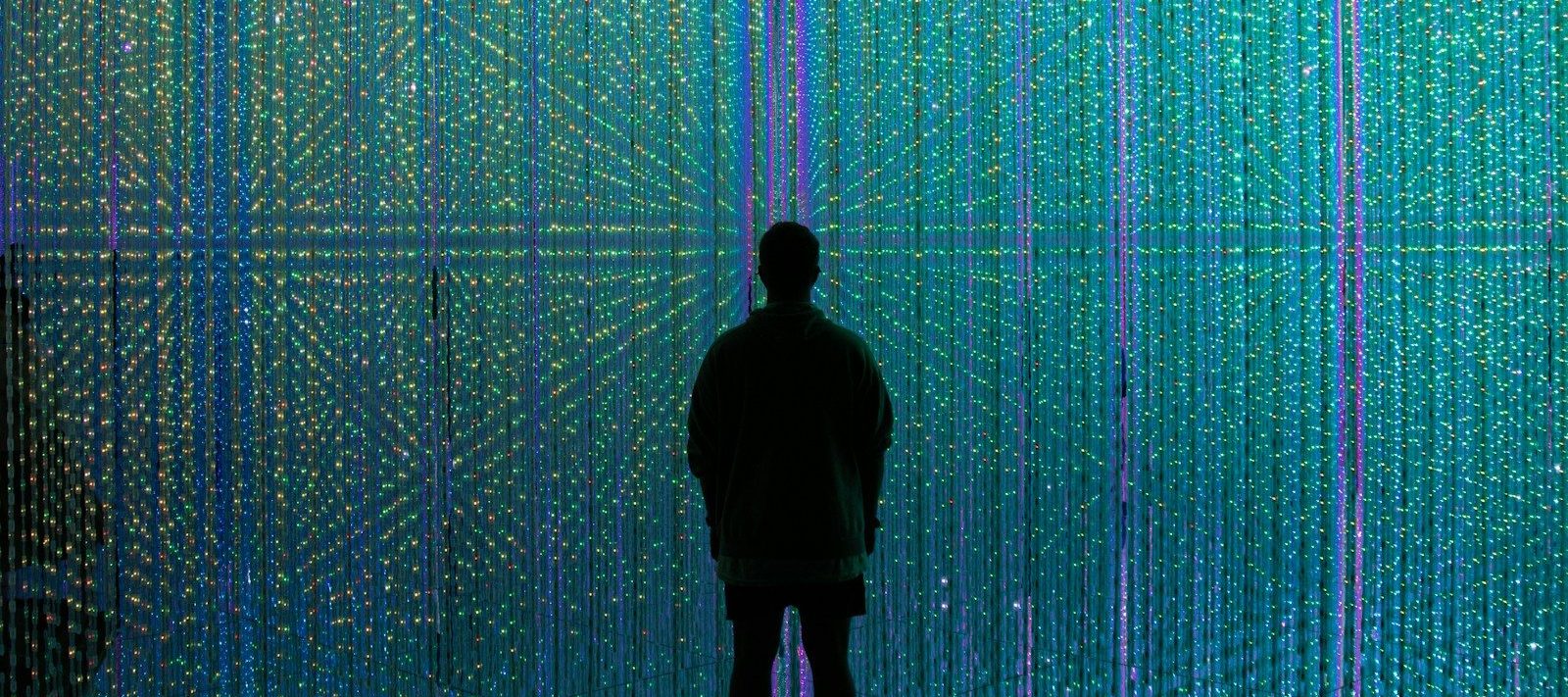 a person standing in front of a wall of lights