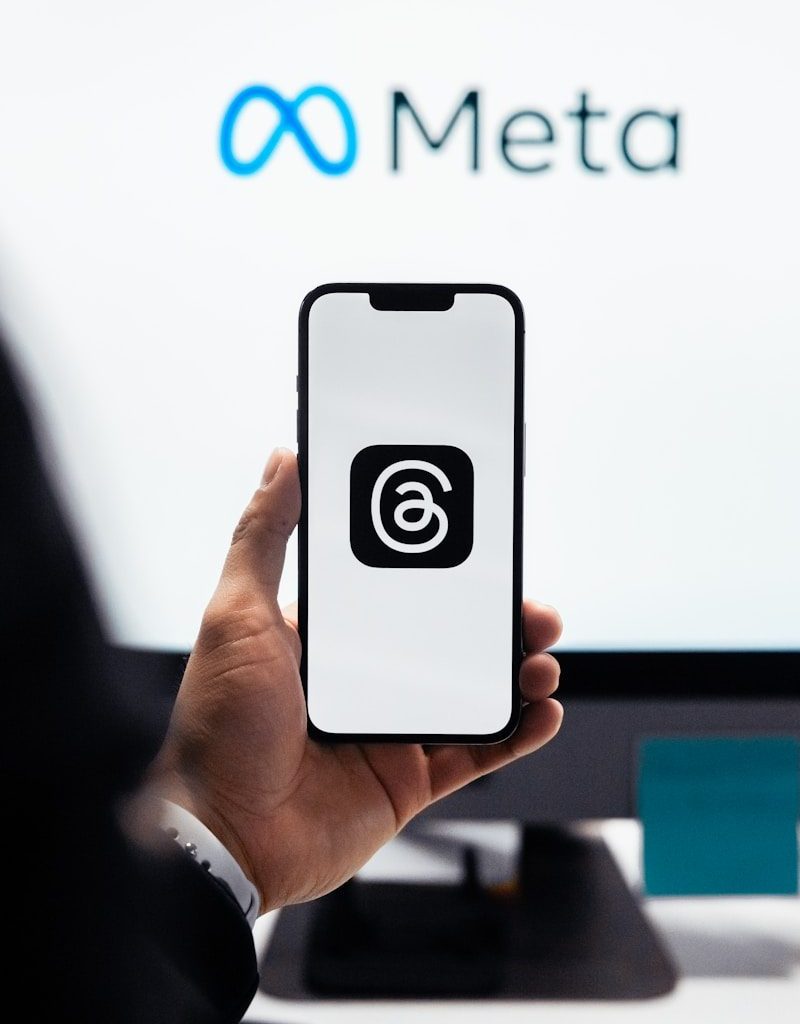 a person holding a cell phone in front of a computer